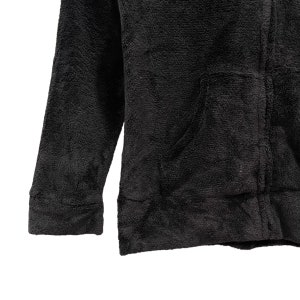 Peut inclure: Une veste en polaire noire avec une fermeture &eacute;clair et une poche sur le devant.