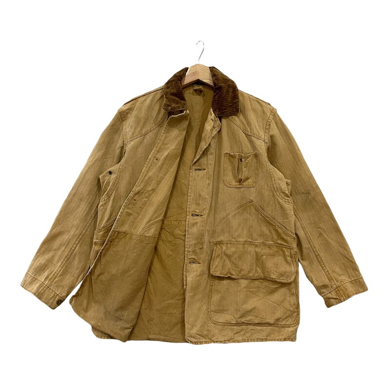 May include: A brown corduroy-collared jacket with multiple pockets and a button-up front. The jacket is made of a thick, durable fabric and has a worn, vintage look.