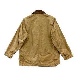 May include: A brown corduroy-collared jacket with a faded, worn look. The jacket has a button-up front and two pockets on the front.