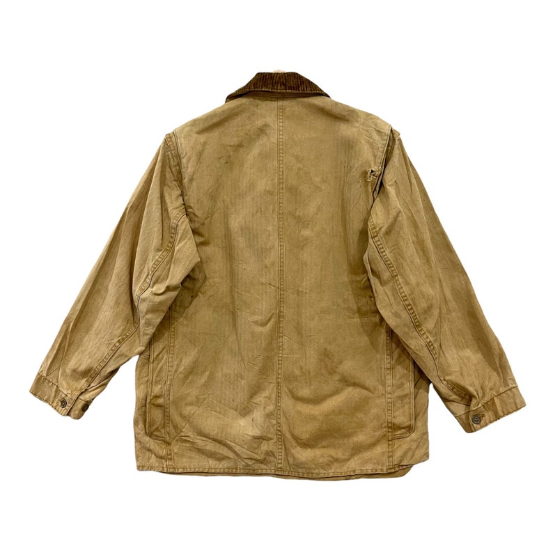 May include: A brown corduroy-collared jacket with a faded, worn look. The jacket has a button-up front and two pockets on the front.