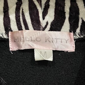 May include: A black and white zebra print fabric with a pink label that says "H&M" and a white tag with the letter "M" on it.