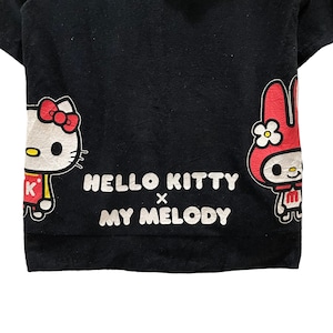 May include: Black t-shirt with Hello Kitty and My Melody characters. Hello Kitty is on the left with a red bow, and My Melody is on the right. The text "HELLO KITTY x MY MELODY" is printed in white across the centre.