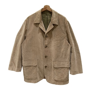 Puede incluir: Un blazer de pana color beige con un dise&ntilde;o cl&aacute;sico. La chaqueta presenta solapas con muescas, cierre de cuatro botones y dos bolsillos delanteros. El forro interior es de color verde oliva en contraste. El blazer est&aacute; colgado de una percha de madera.