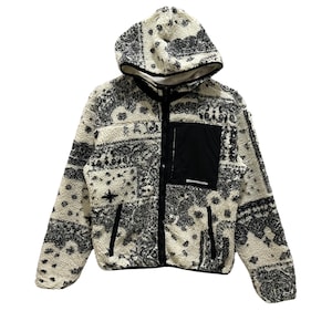 May include: A white and black patterned fleece jacket with a hood and zip closure. The jacket has a black pocket on the left side with the text "Snow Peak" in white.