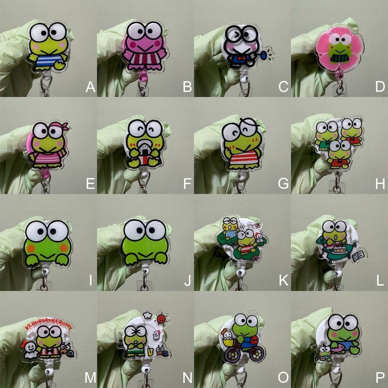 Op de afbeelding: Een set van 16 verschillende Keroppi-personage-badge-rollen. Elke rol heeft een ander Keroppi-ontwerp, waaronder Keroppi in een badpak, Keroppi met een drankje, Keroppi met vrienden en Keroppi op een fiets. De rollen zijn gemaakt van helder plastic en hebben een metalen clip.