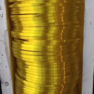 May include: A stack of yellow plastic bangles. The bangles are stacked on top of each other and are arranged in a circular pattern.