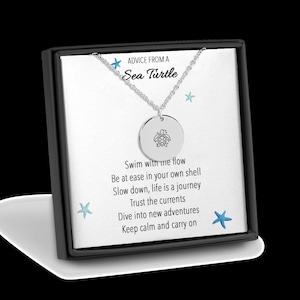 May include: A silver necklace with a round pendant featuring a sea turtle design. The pendant is engraved with the words "Advice from a Sea Turtle" and a poem about swimming with the flow, being at ease, and trusting the currents.