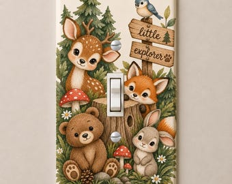 May include: A rectangular light switch cover featuring a forest scene with a fawn, a fox, a brown bear, and a rabbit. The design includes green pine trees, red mushrooms, and a wooden signpost with the text little explorer and a paw print.