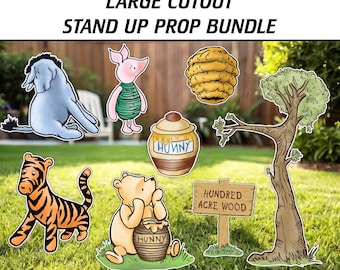 May include: A set of Winnie the Pooh themed cardboard stand-up props. The set includes Winnie the Pooh, Piglet, Eeyore, a honey pot, a beehive, a sign that says "Hundred Acre Wood", and a tree.