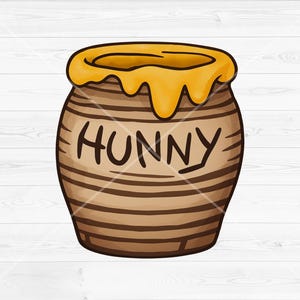 May include: A brown ceramic honey pot with horizontal dark brown stripes and a yellow honey drip design around the rim. The word HUNNY is written in dark brown capital letters on the front of the pot, which has a rounded shape and a wide opening.