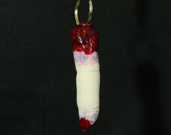 Severed finger horror keychain with bone sticking out and fake blood
