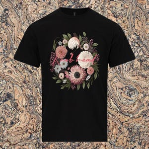 May include: Black t-shirt with a floral design and the text "knob head" in pink.