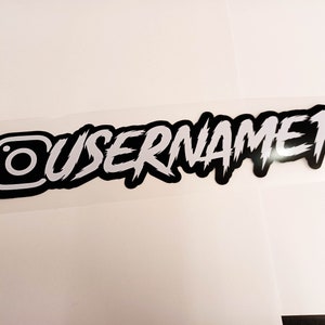 May include: Black and white Instagram sticker with the text "USERNAME1" in a stylized font.