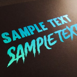 May include: A blue and teal gradient text graphic on a black background. The text reads "SAMPLE TEXT SAMPLE TEXT".