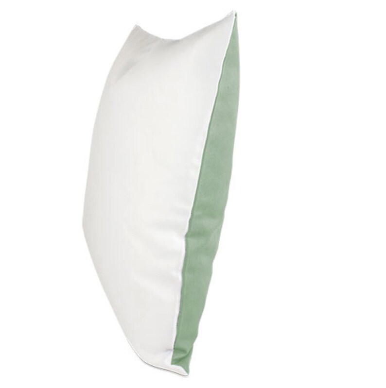 May include: A white pillow with a sage green border. The pillow is shown from the side.