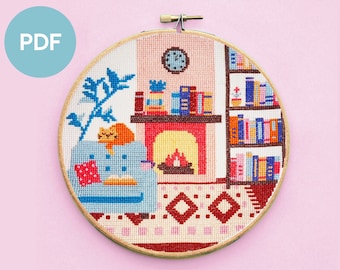 May include: A cross-stitch pattern of a cozy living room with a fireplace, a bookshelf filled with books, a cat napping on a couch, and a plant in the corner. The pattern is framed in a wooden hoop.