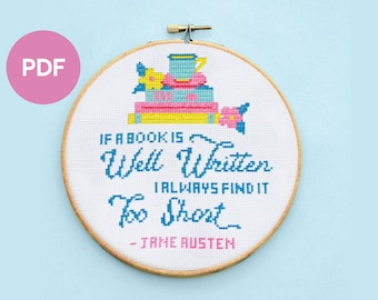 Op de afbeelding: Een borduurring met kruissteek met een witte achtergrond en een citaat van Jane Austen: "Als een boek goed geschreven is, vind ik het altijd te kort." Het citaat wordt omringd door kleurrijke illustraties van boeken, een theekopje en bloemen.
