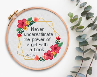 Può includere: Arte ricamata a cerchio con una ghirlanda di fiori e la citazione "Non sottovalutare mai il potere di una ragazza con un libro -RBG-"