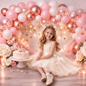 Könnte beinhalten: Ein junges Mädchen in einem cremefarbenen Kleid sitzt vor einem Ballonbogen aus rosa, roségoldenen und weißen Ballons. Ein Kuchen steht auf einem weißen Ständer, umgeben von Blumen und Kerzen. Der Hintergrund umfasst sternförmige Lichter.