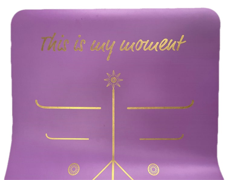 May include: Purple yoga mat with gold lettering that says "This is my moment" and gold geometric designs.