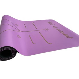 May include: A purple yoga mat with a black border and a gold inscription that reads "This is my workout".