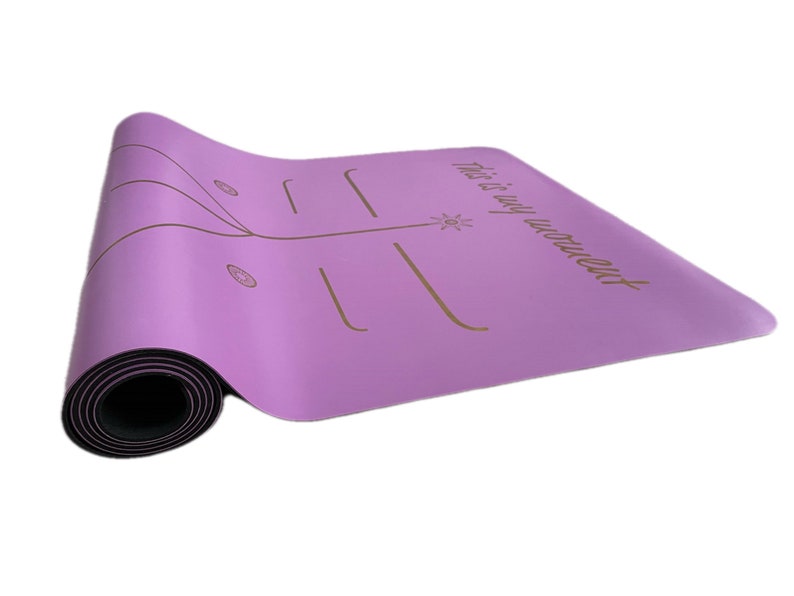 May include: A purple yoga mat with a black border and a gold inscription that reads "This is my workout".