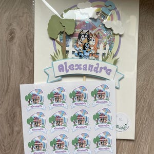 K&ouml;nnte beinhalten: Ein Satz mit 12 runden Aufklebern mit einem Cartoon-Bild eines Hauses mit einem Regenbogen und dem Namen "Alexandre" auf einem Banner. Die Aufkleber sind auf wei&szlig;em Papier mit gl&auml;nzender Oberfl&auml;che gedruckt.