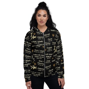 Könnte beinhalten: Schwarze Bomberjacke mit goldfarbenem Druck von inspirierenden Zitaten und Bibelversen. Der Text enthält "Ich bin", "Gesegnet", "Auserwählt", "Erlöst", "Geliebt", "Vergeben", "Ermächtigt", "Bekannt und Akzeptiert", "Im Bild geschaffen", "Es lohnt sich zu leben und zu sterben", und mehr.