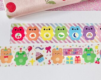 May include: A roll of decorative tape with a bear face design and the text "happyfillbear". Two additional tapes feature colorful bear and frog characters with various designs, including cherries, rainbows, and birthday elements.