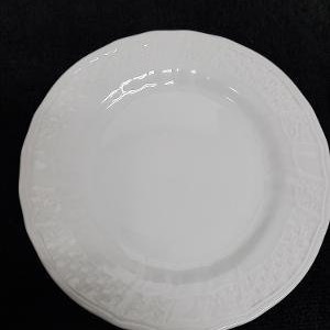 May include: A white ceramic plate with a decorative, embossed pattern around the edge.