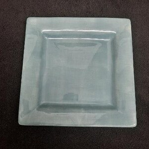 May include: A light blue ceramic square serving dish with a raised rim.