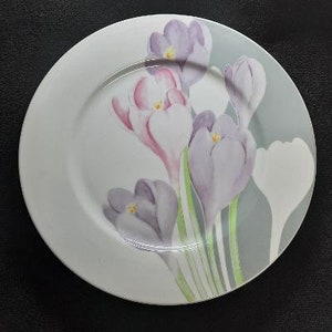 May include: A white ceramic plate with a gray and white design featuring purple and pink crocuses.