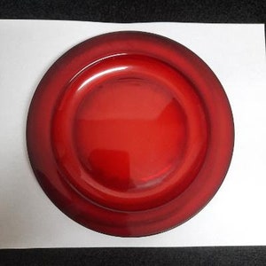 May include: A deep red charger plate with a raised rim and a glossy finish.
