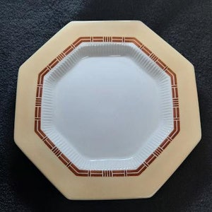 May include: A white octagonal ceramic plate with a brown geometric pattern around the edge.