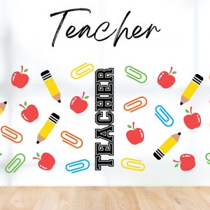 May include: White background with the word "Teacher" written in black cursive at the top. The word "Teacher" is repeated vertically in black block letters in the centre of the image. The background is decorated with a pattern of red apples, yellow pencils, and colourful paper clips.