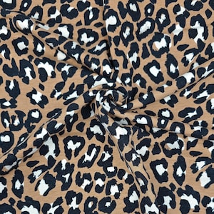 Könnte beinhalten: Brauner Stoff mit einem schwarzen und weißen Leopardenmuster.