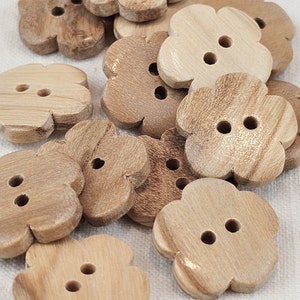 Könnte beinhalten: Eine Sammlung von holzschen Blütenknöpfen mit jeweils zwei Löchern. Die Knöpfe sind hellbraun und haben eine natürliche Holzmaserung.