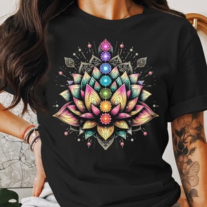 May include: Black t-shirt with a colorful mandala design featuring a lotus flower and seven chakras. The chakras are represented by different colors, including red, orange, yellow, green, blue, indigo, and violet.