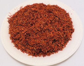 May include: A white plate with a pile of dried red safflower petals.