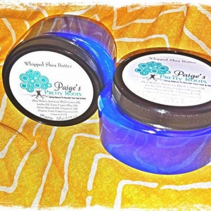 May include: Two blue jars of whipped shea butter with black lids and white labels. The labels have the text "Whipped Shea Butter" and "Paige's Pretty Roots" with a logo of a tree with circles around it. The text "Mango Madness" is on the label of the jar in the foreground.