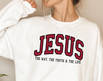 Może przedstawiać: Biała bluza z napisem "JESUS THE WAY, THE TRUTH & THE LIFE" w czerwonych literach.