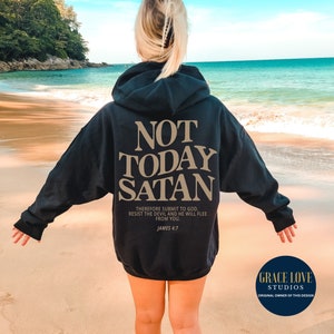 May include: Black hoodie with the text "NOT TODAY SATAN" in gold lettering. The text "THEREFORE SUBMIT TO GOD. RESIST THE DEVIL AND HE WILL FLEE FROM YOU. JAMES 4:7" is also printed in gold lettering below the main text.