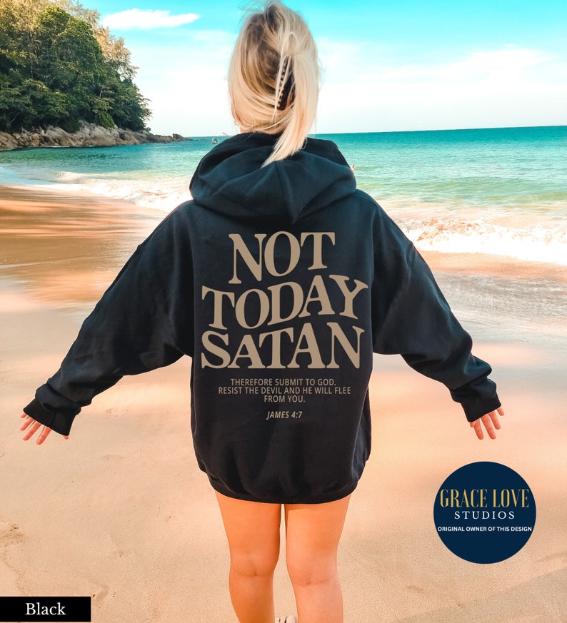 May include: Black hoodie with the text "NOT TODAY SATAN" in gold lettering. The text "THEREFORE SUBMIT TO GOD. RESIST THE DEVIL AND HE WILL FLEE FROM YOU. JAMES 4:7" is also printed in gold lettering below the main text.