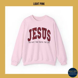 Może przedstawiać: Jasnor&oacute;żowy sweter z napisem "JESUS" w czerwonym łuku nad tekstem "THE WAY, THE TRUTH, THE LIFE".