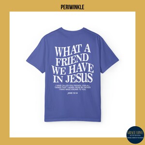 Peut inclure: Un t-shirt bleu avec du texte blanc qui dit "What a friend we have in Jesus." Le texte est en gras, sans empattement. En dessous du texte se trouve une citation de Jean 15:14. "Je vous ai appel&eacute;s amis, car tout ce que j'ai entendu de mon P&egrave;re, je vous l'ai fait conna&icirc;tre. Jean 15:14"