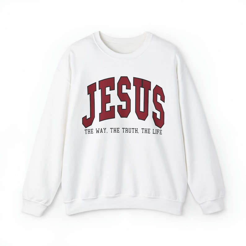 Może przedstawiać: Biała bluza z czerwonym nadrukiem "JESUS" i tekstem "THE WAY, THE TRUTH, THE LIFE" poniżej.