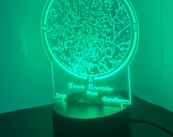 May include: A green LED night light with a circular design featuring a star map and compass points. The light has a black base and includes the text "Your Names", "Date", "Place", and "Coordinates".
