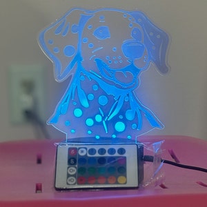 May include: A blue and white Dalmatian dog night light with a remote control to change the colour of the light. The remote has 16 different colour options.