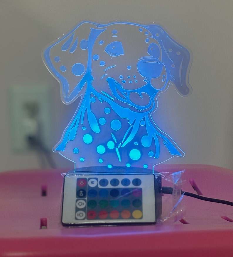 May include: A blue and white Dalmatian dog night light with a remote control to change the colour of the light. The remote has 16 different colour options.