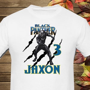 May include: White t-shirt with a black and gold "Black Panther" graphic, a black panther character, and the text "Jaxon" and "3" in blue.
